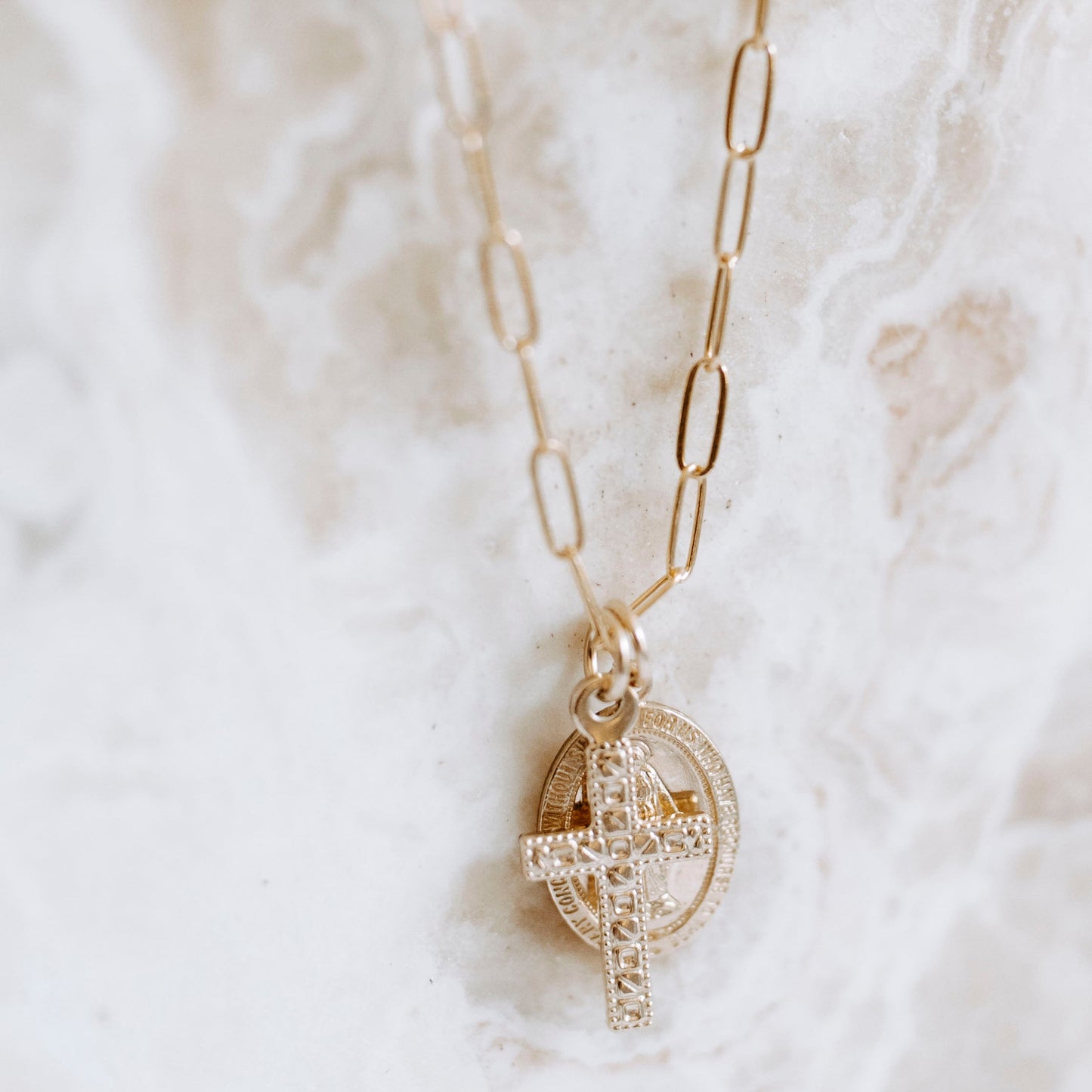 lose-up of 14k gold filled Virgin Mary medallion and textured cross charm