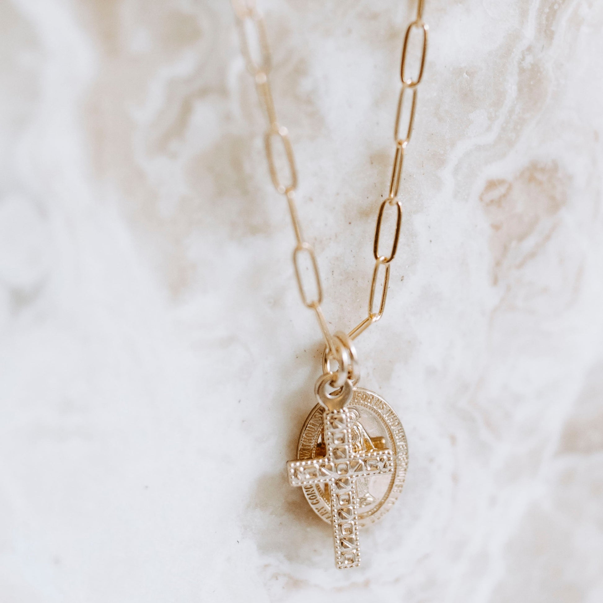 lose-up of 14k gold filled Virgin Mary medallion and textured cross charm